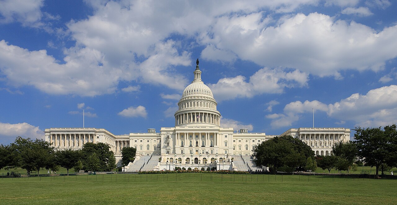 Westfassade des US-Kapitols in Washington, D.C., vor blauem Himmel.